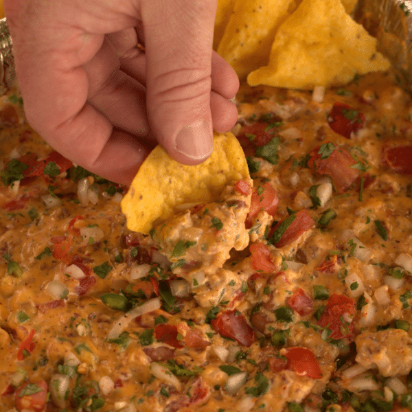 Corn tortilla chip dipped in smoked queso.